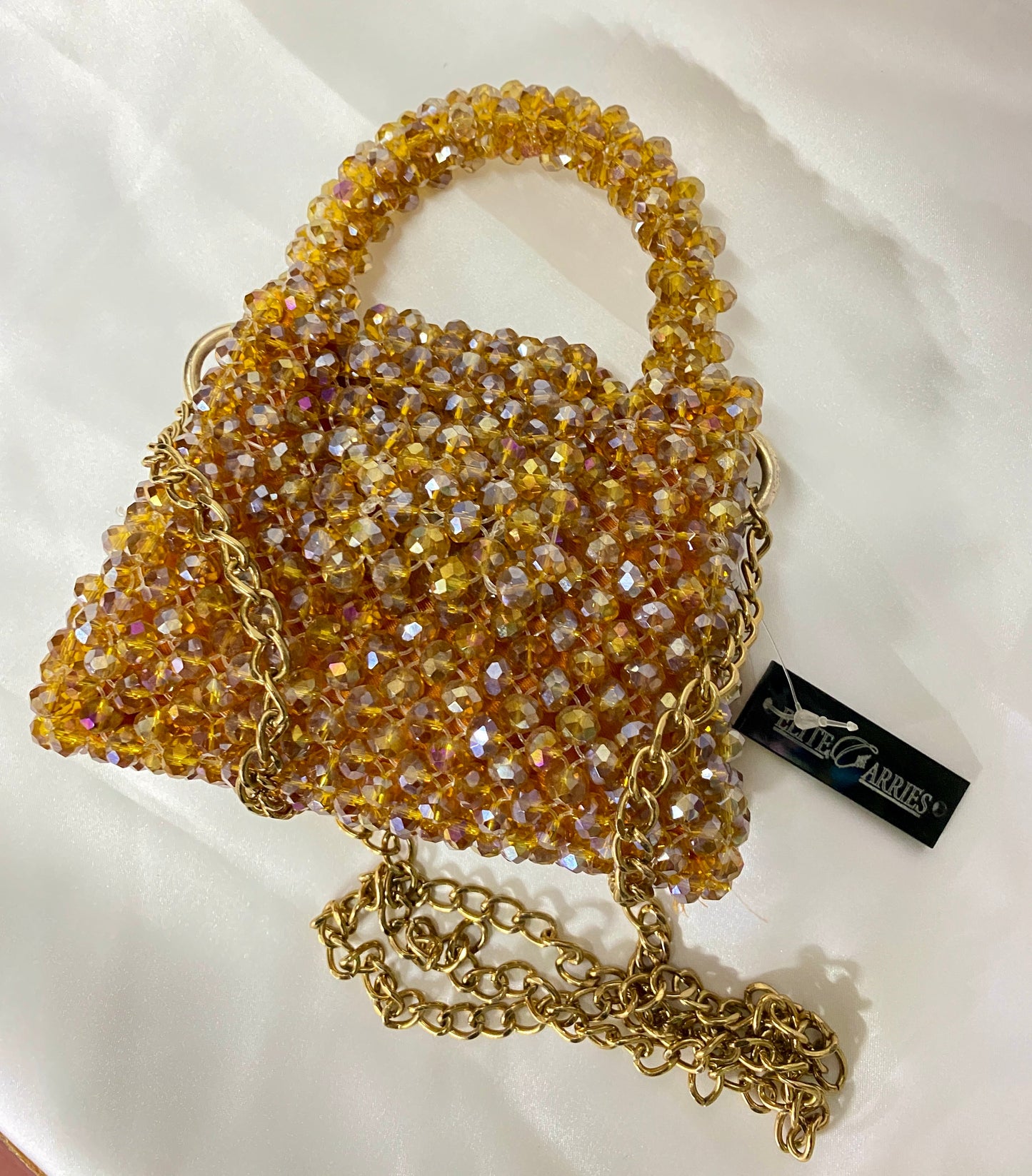 Gold beaded handbag with chain strap on a white background