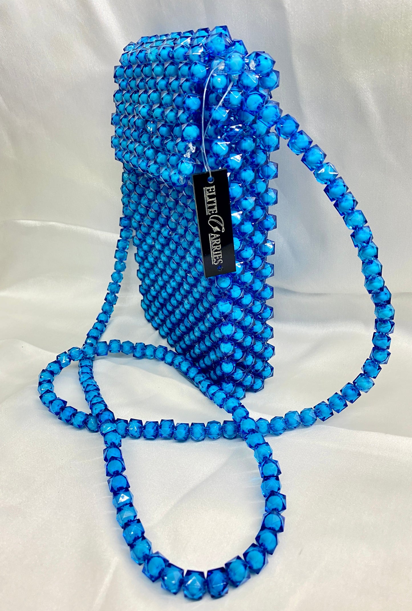 Blue beaded handbag with a long strap on a white background