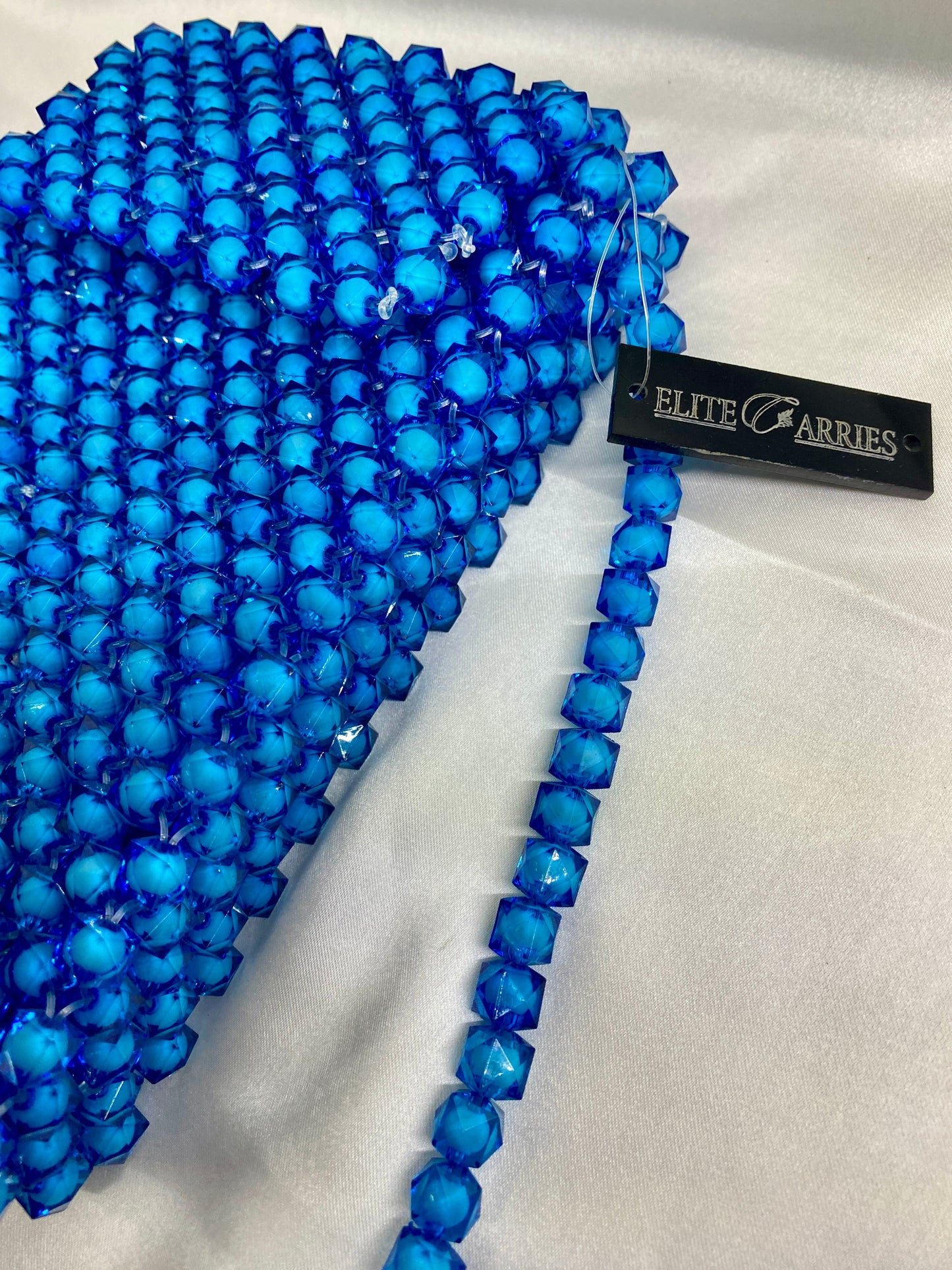 Blue beaded necklace with a visible brand tag on a white background
