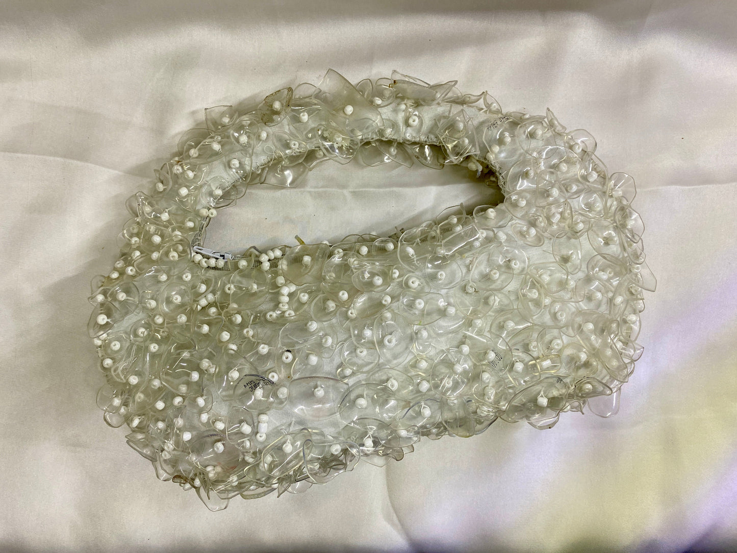 Decorative headband with pearls on a light fabric background