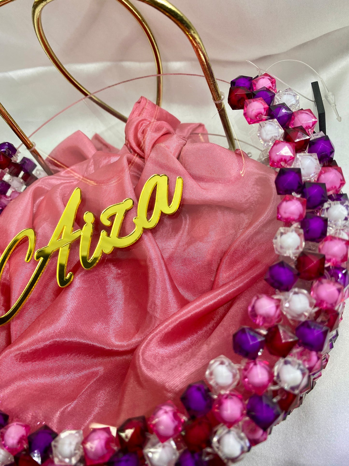 Decorative headband with pink satin bow and colorful beads on a white background
