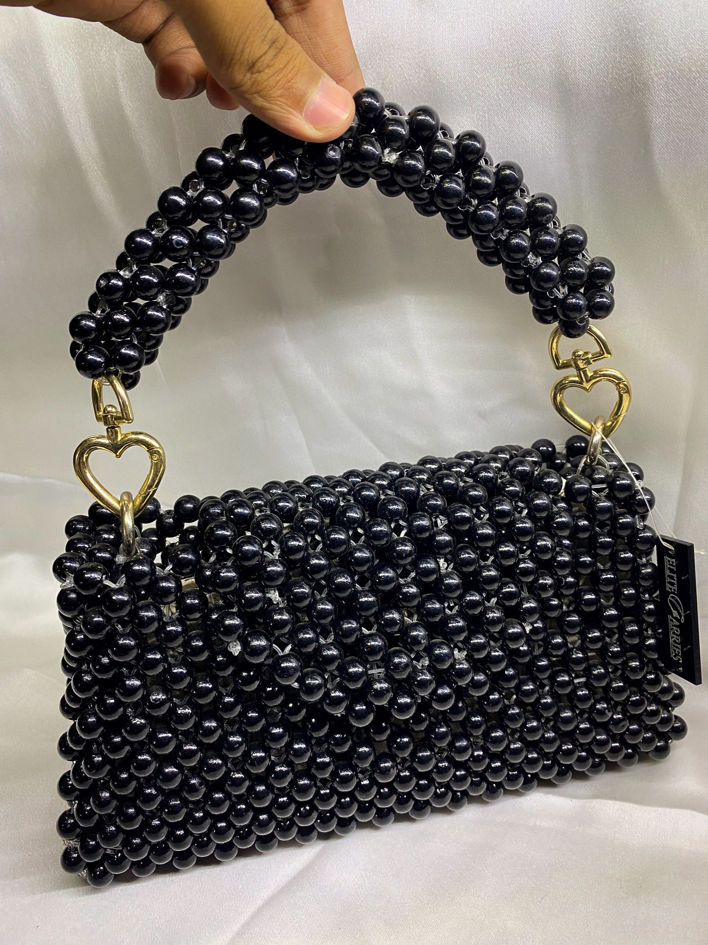 Close-up of Pearl Noir clutch – white beaded evening bag with chain