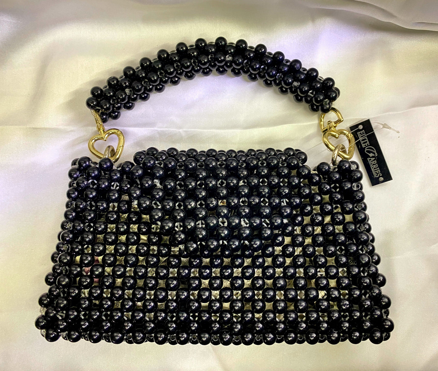 Black beaded handbag with gold accents on a white background