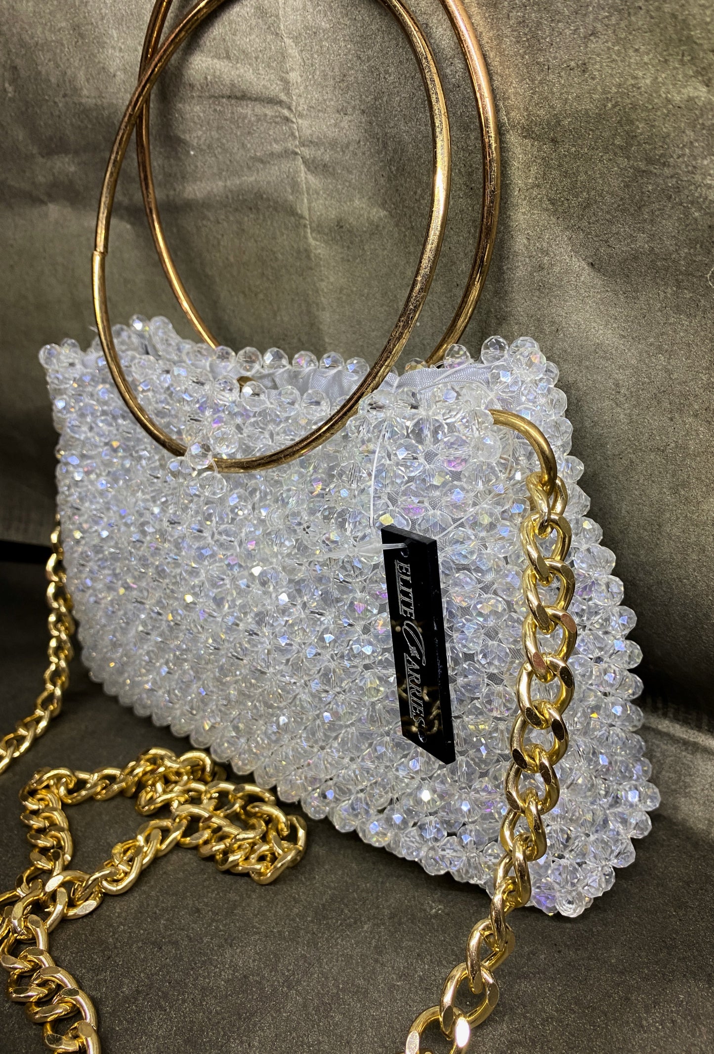 Sparkly handbag with gold chain strap on a neutral background