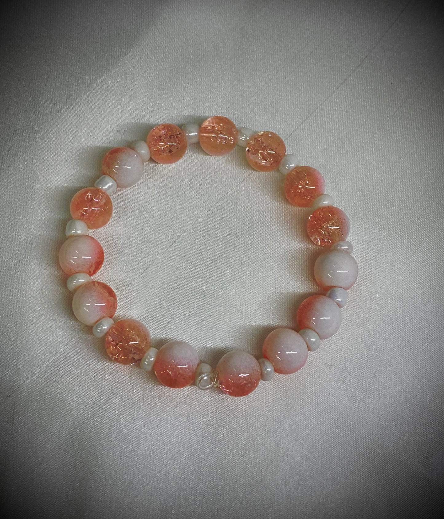 Beaded bracelet with pink and white beads on a light gray background