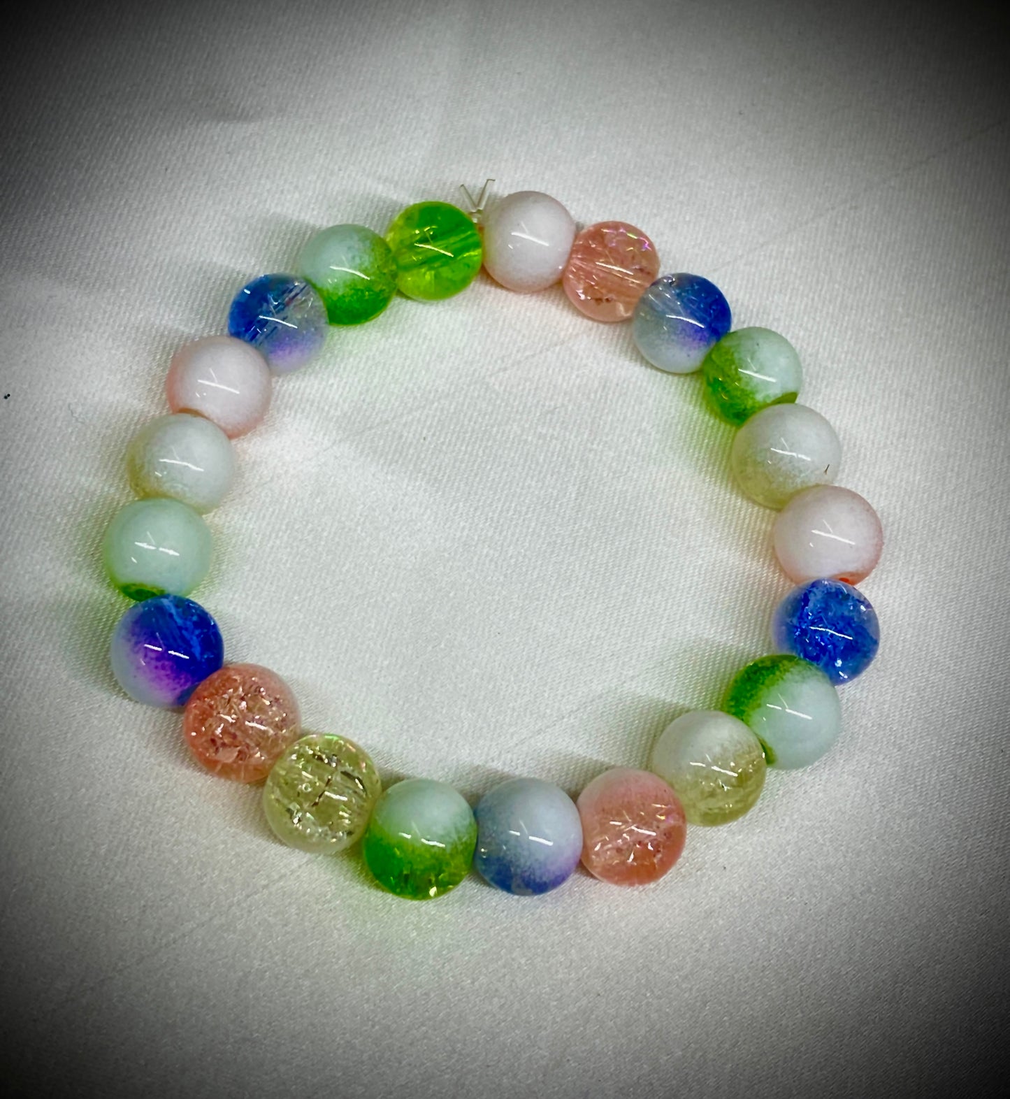 Multicolored beaded bracelet on a white fabric background