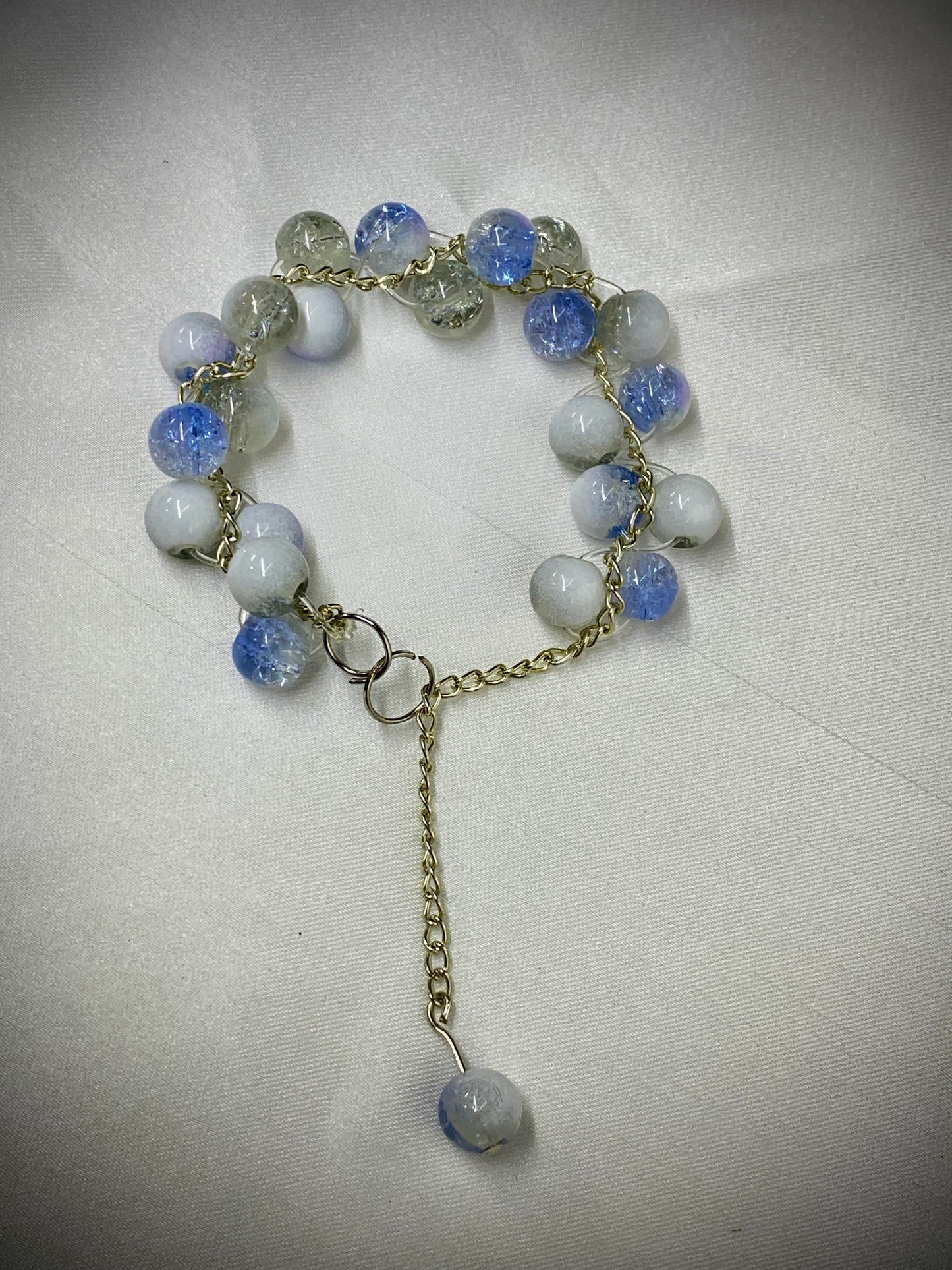 Bracelet with blue and white beads on a light gray background