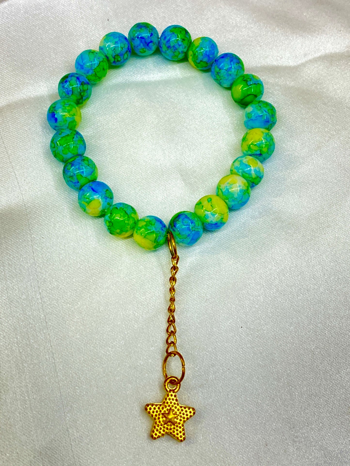 Beaded bracelet with a gold star charm on a white background