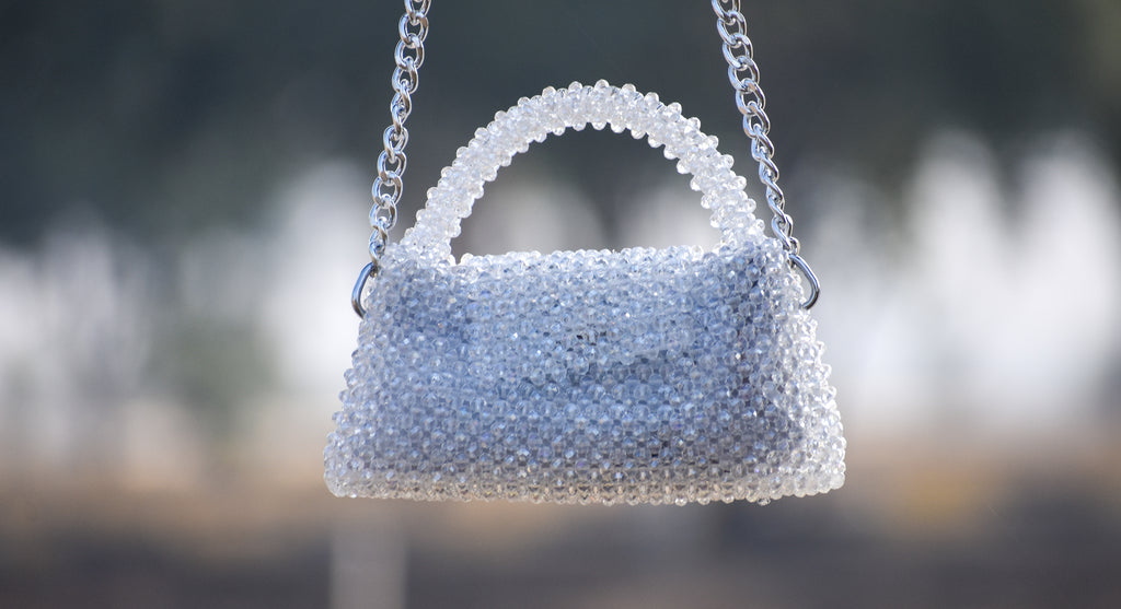 Handbag made of white beads with a blurred background