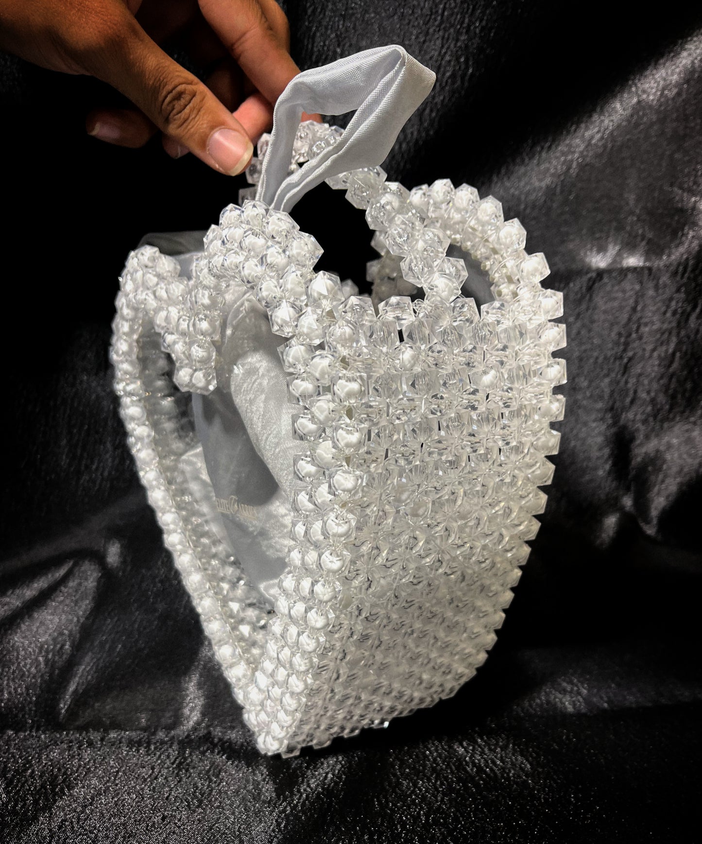 A radiant handmade heart-shaped handbag, featuring a dreamy white glow and elegant design