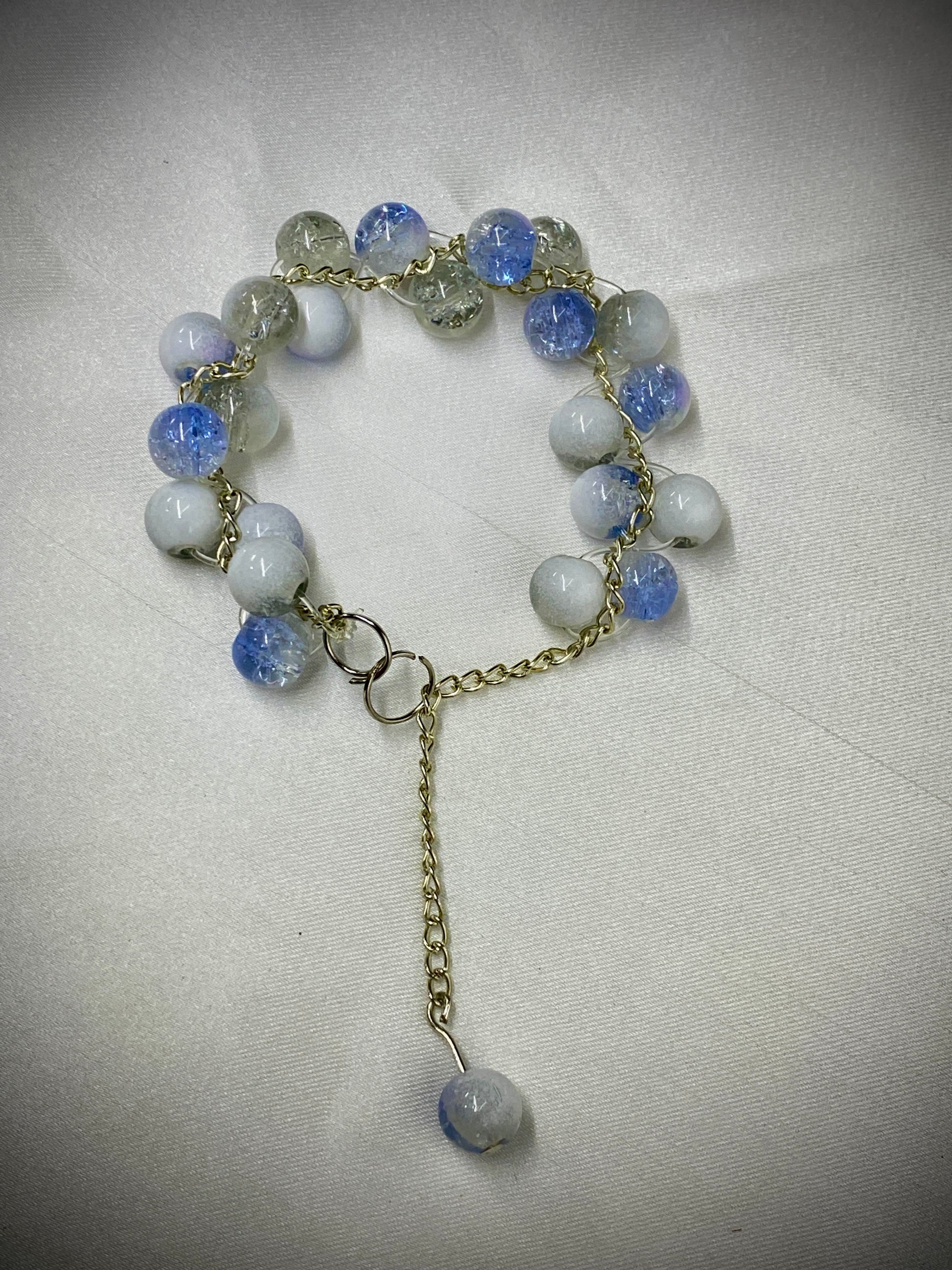 Bracelet with blue and white beads on a light gray background