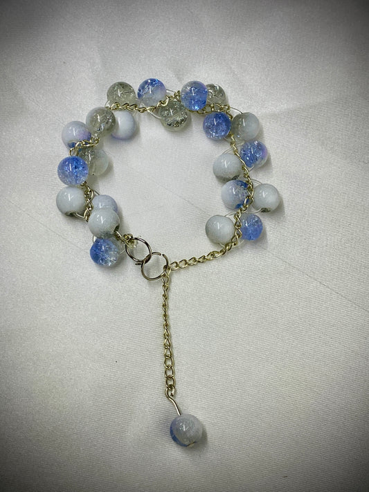 Bracelet with blue and white beads on a light gray background