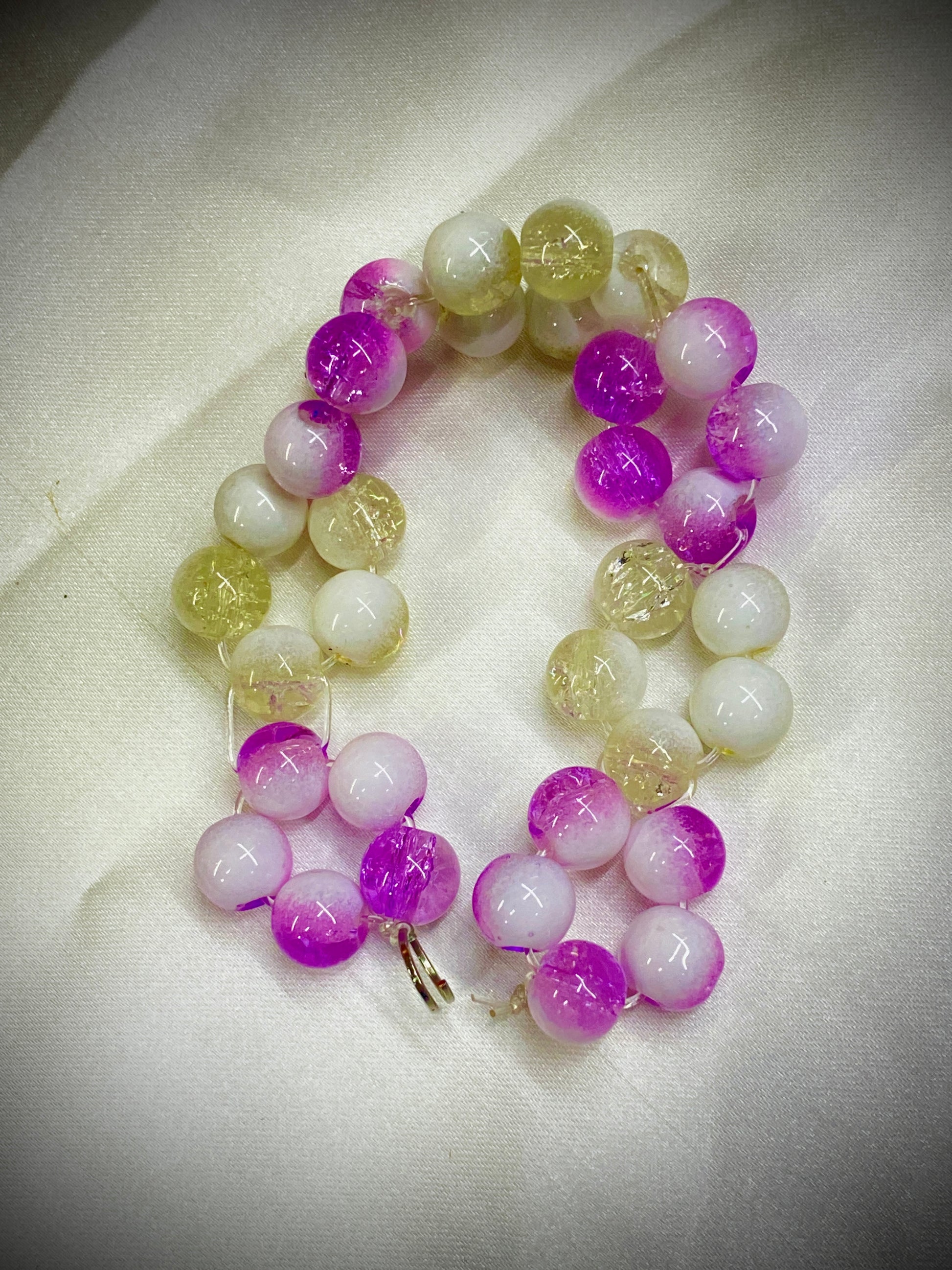 Multicolored beaded bracelet on a light fabric background