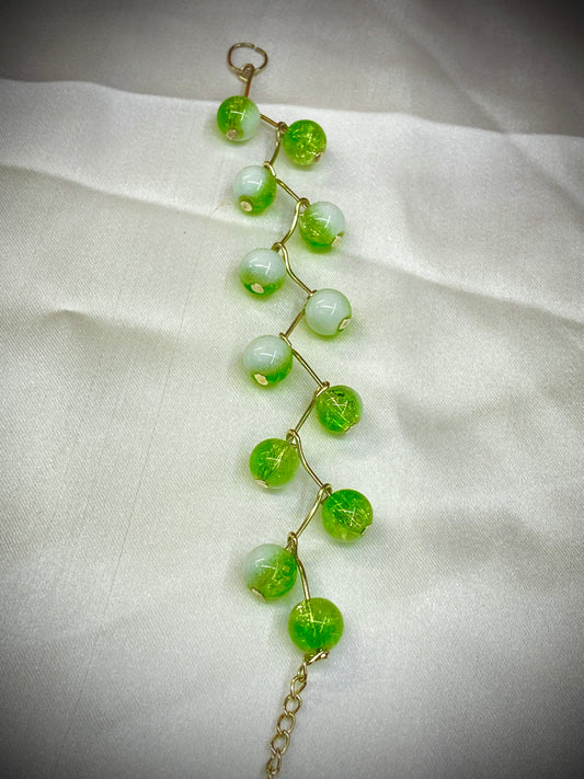 Green beaded bracelet on a white fabric background