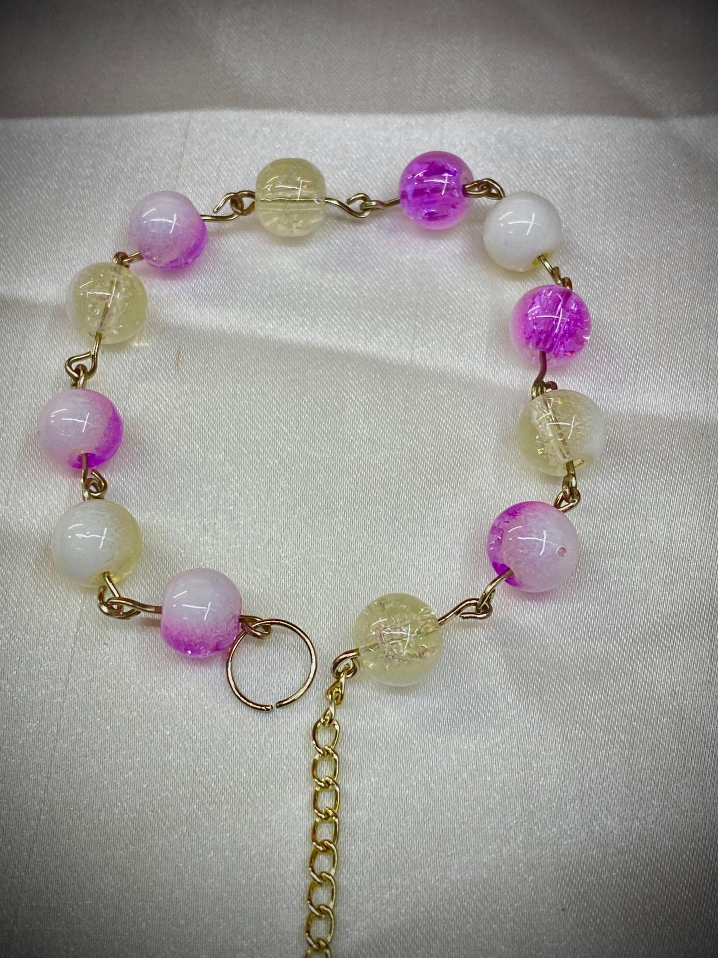 Necklace with pink and clear beads on a white fabric background