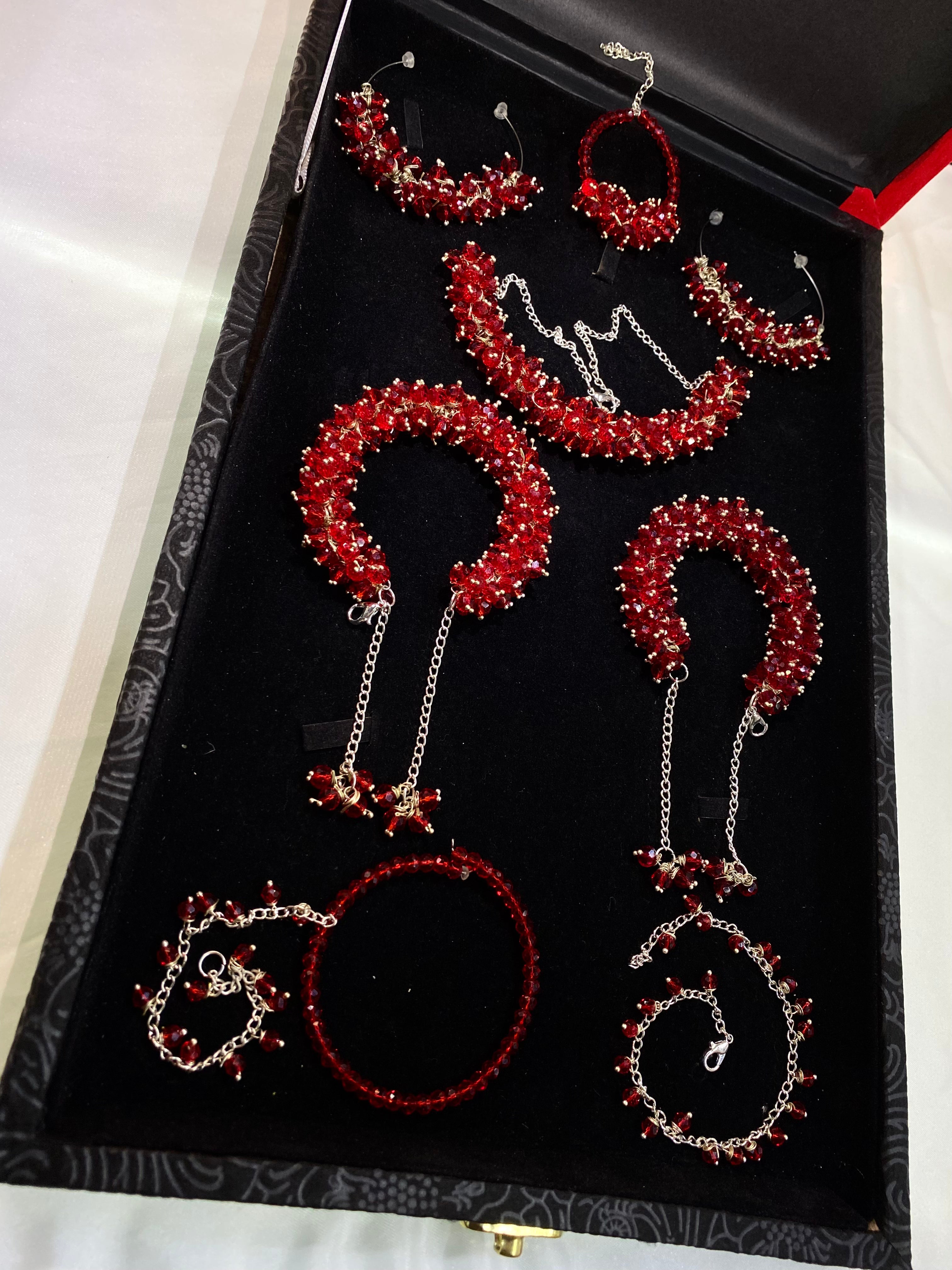 Set of red and silver jewelry pieces in a black box