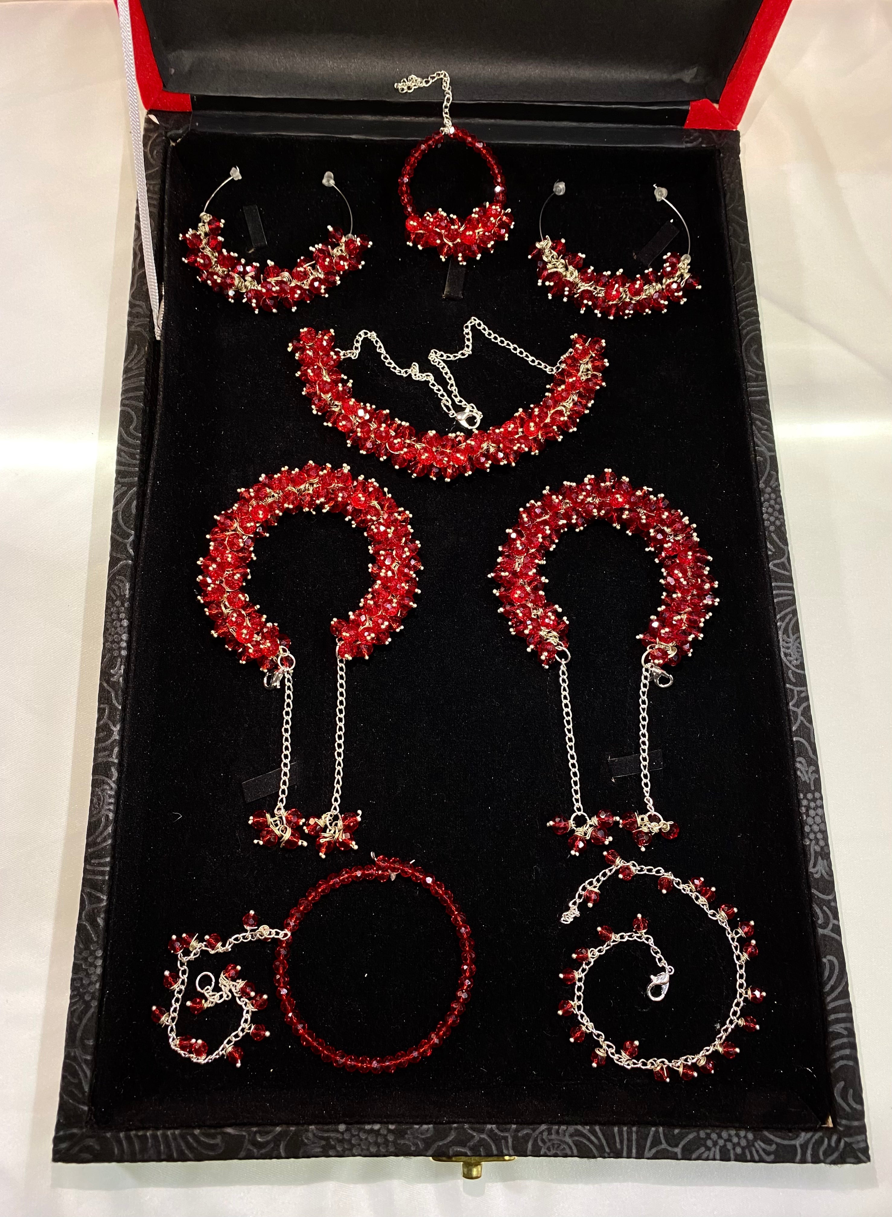 Jewelry set with red and silver earrings displayed in an open jewelry box.