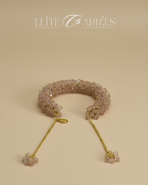 Delicate bracelet with beaded design and gold chain on a beige background, featuring the brand 'Elite Carries'.