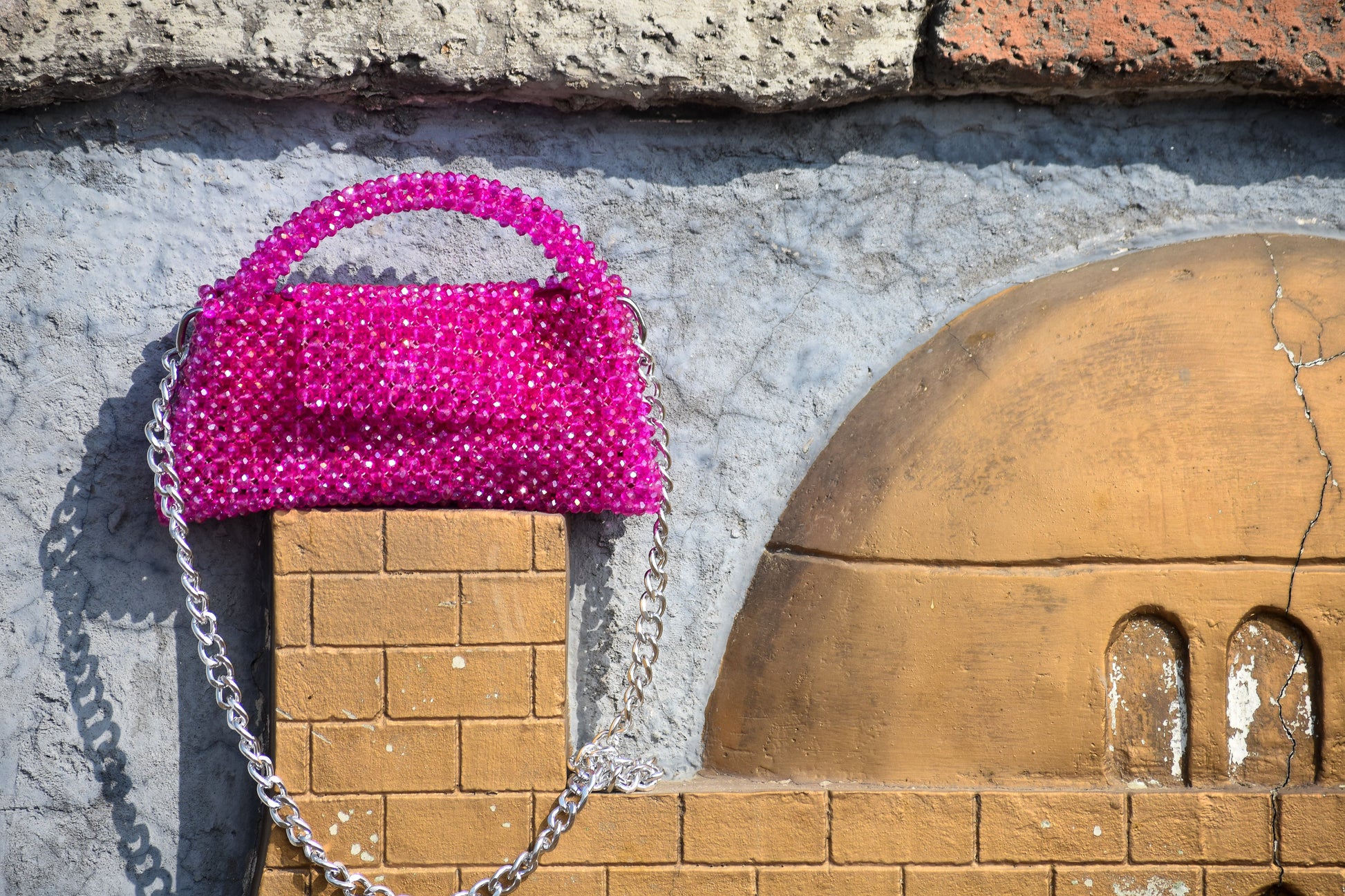 A close-up of the Magenta Mystique handbag detailing, featuring premium stitching and material.
