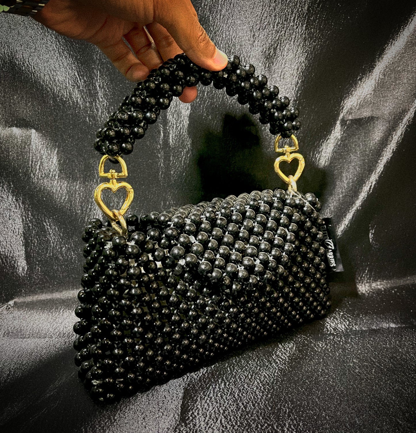 A vibrant Black pearl handbag with shimmering details, crafted for a sophisticated and glamorous look.